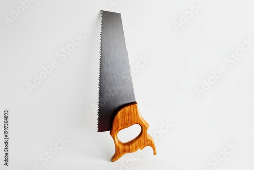 Wood Saw With a Wooden Handle Hanging Against a Plain Background