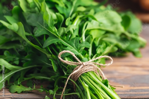 Fresh Arugula Tied With Twine on a Black Wooden Surface in a Kitchen Setting