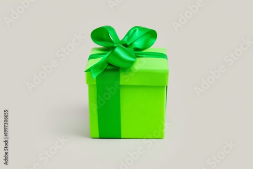 Green Gift Box With a Ribbon Sits on a Plain Background