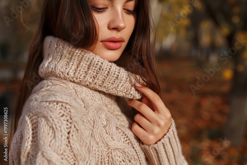 Woman Wearing a Sweater in a Garden During Autumn With Fallen Leaves on the G...