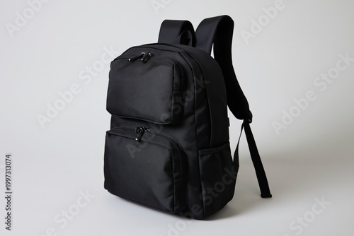Black Backpack on a Stone Surface Near Green Plants in Daylight