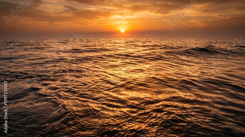 Golden sunset over ocean waves with warm light reflection