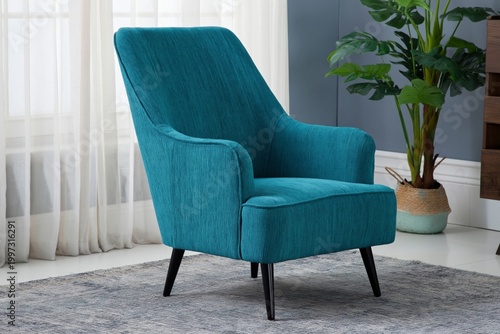 Cushioned Chair in a Room With Natural Light and a Potted Plant Placed Nearby