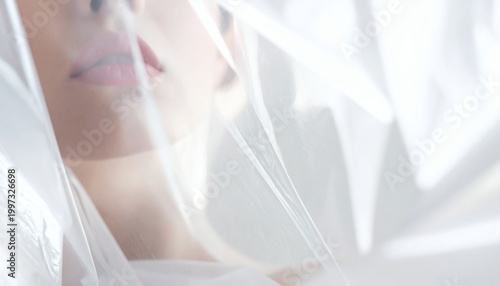 Mysterious beauty portrait of a woman obscured by thin translucent white material