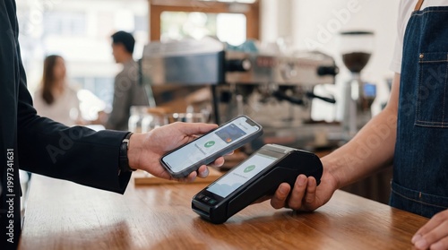 Customer making a contactless mobile payment using a smartphone at a coffee shop counter while the barista holds the point of sale terminal to complete the transaction.