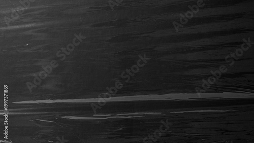 Photography scratch and dust plastic background,plastic overlay texture of crumpled transparent plastic film wrap on black background,wrinkled stretched plastic effect