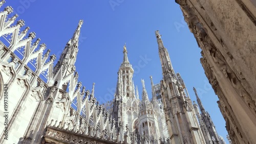 Nice view of Milan Madonnina and marble statues at sunny day background blue sky, duomo cathedral rooftop view point,Milan, Italy