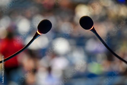 Fotografie Close-up of two active gooseneck microphones with red light indicators at a larg