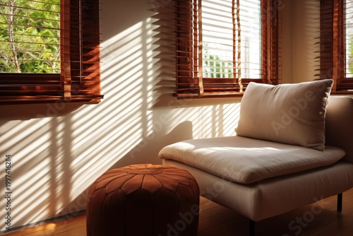 Natural Light Shines Through Windows Onto a Chair and Ottoman in a Room Durin...