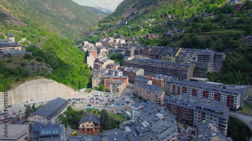 aerial view showcases the picturesque townscape nestled within the mountainous terrain of Andorra, highlighting the unique architecture and natural beauty of the region, likely Encamp. This footage ca