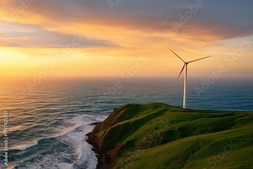 Wind Turbine Stands on a Green Hill Overlooking the Ocean at Sunset Near a Co...