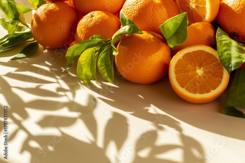Fresh Oranges With Green Leaves Casting Shadows on a White Surface in Daylight