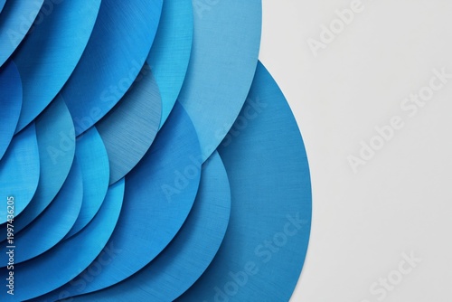Soft Blue Fabric Arranged in Smooth Curves on a Solid Blue Background in a St...