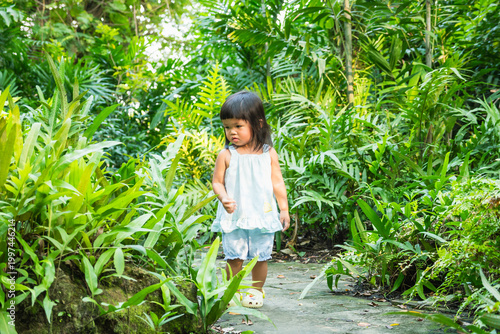Bild auf Leinwand Adventurous child exploring lush greenery tropical garden nature close-up view