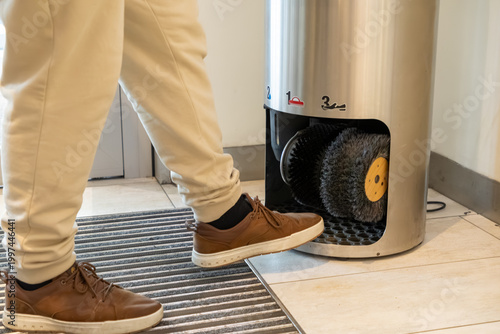 Photography A professional person uses an automatic shoe polishing machine in a modern offic