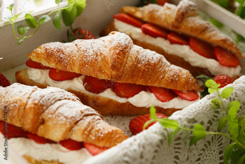 Foto Croissants with strawberries and whipped cream, close-up