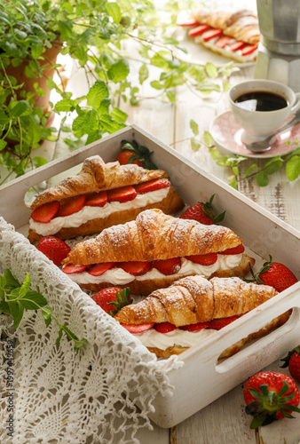 Foto Croissants with strawberries and whipped cream, close-up