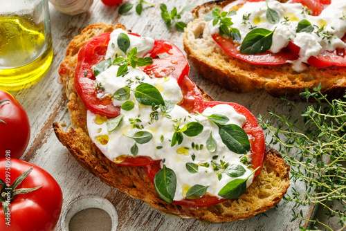 Grilled sandwiches with burrata cheese, fresh tomatoes and herbs, close up view