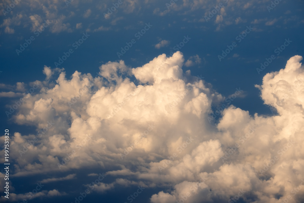 Obraz premium Cloudy sky, from airplane window point of view. View from above at high altitude of dense puffy cumulus clouds