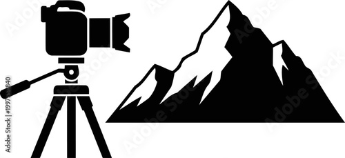 Professional dslr camera on a tripod facing mountains silhouette