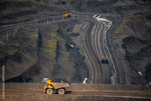 Fotografía Expansive open pit mine with heavy machinery operating on rugged terrain, truck