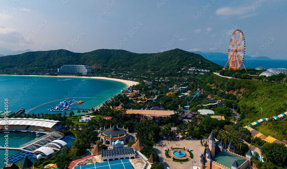 Fototapeta premium Aerial view of coastal amusement park with ferris wheel and beach, travel trip Nha trang, Vietnam
