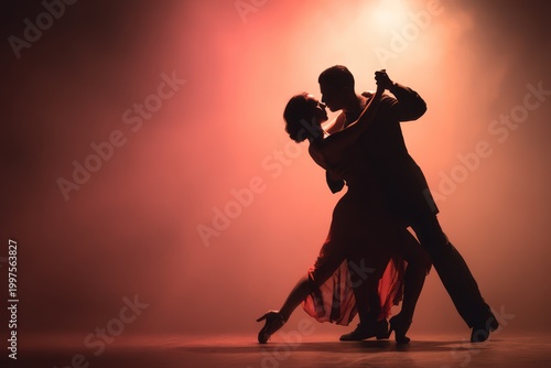 Dramatic tango dancers embrace and light