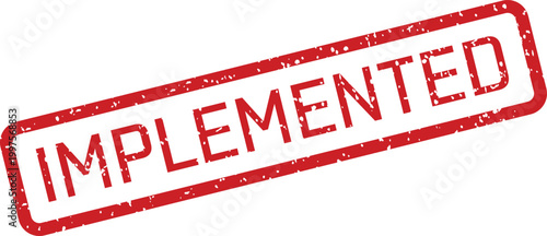 A textured red rectangular rubber stamp clearly showing the capitalized word IMPLEMENTED on a plain white surface