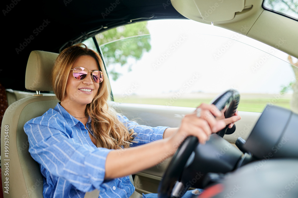 Naklejka premium Woman driving convertible car on road trip, enjoying freedom