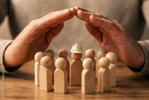 Protective hands covering wooden figures with one wearing hard hat illustrating industrial worker insurance for world day for safety and health at work global initiative