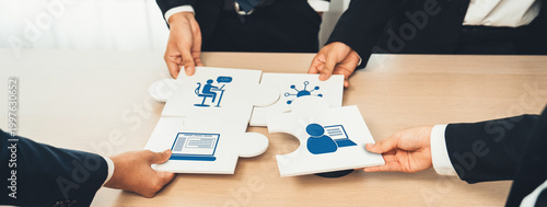 Фотография Business professionals come together, connecting puzzle pieces in a symbolic act of collaboration, teamwork, and strategic planning in a modern office setting