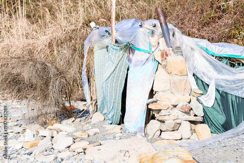 Schilderij op canvas Makeshift stone hut in rocky terrain with dry grass