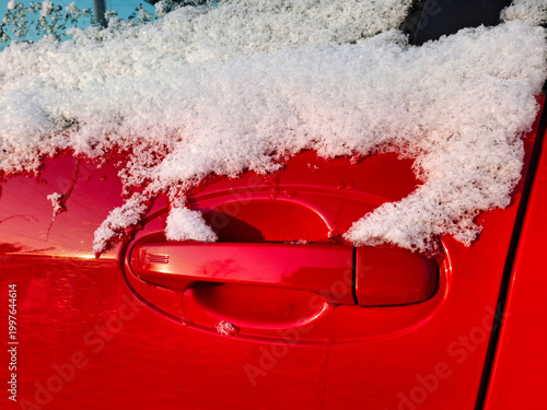 Canvastavla The side window and door handle of the red car are dusted with snow