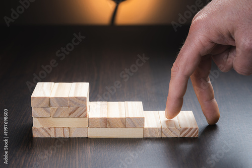 Cuadro en lienzo Goals of success and business progress, represented by a hand climbing a ladder of wooden cubes