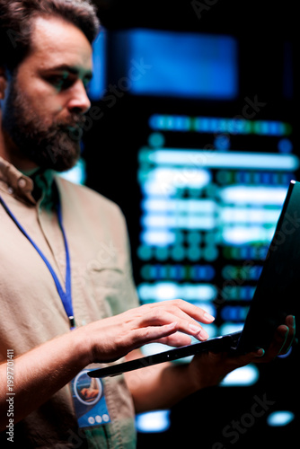 Cuadro en lienzo Serviceman doing system analysis, typing data on laptop of needed adjustments in