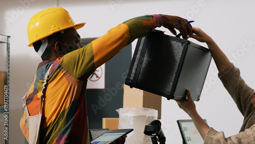 Canvas Print Diverse people checking computer list with orders, reviewing packages for shipping in warehouse depot