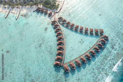 Foto Aerial view of overwater bungalow huts in Maldives with turquoise lagoon and san