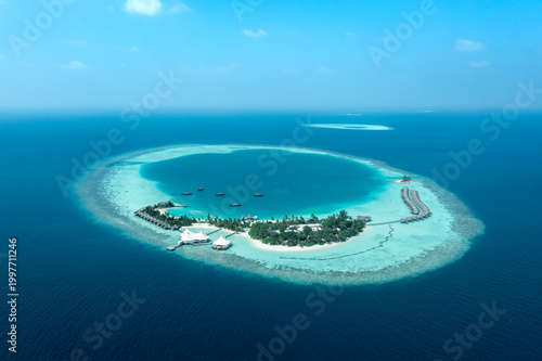 Fotografija Wide aerial view of Maldives resort island surrounded by lagoon with distant ato