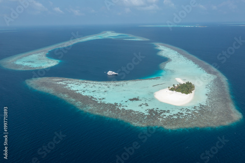 Photos Wide aerial shot of luxury diving liveaboard yacht parked near Maldives atoll re