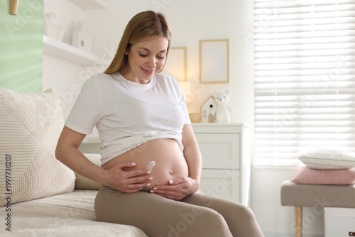 Pregnant woman applying cream on her belly at home, space for text Free Download Pregnant woman applying cream on her belly at home, space for text - GFXLoad