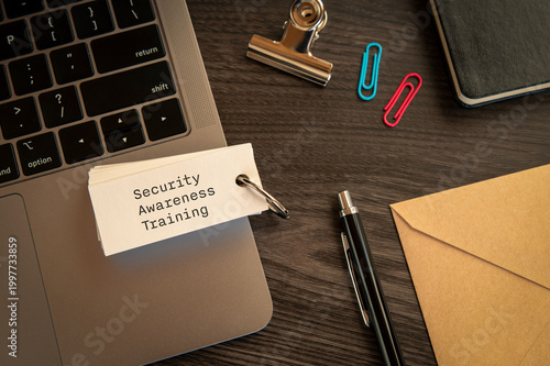 Secure technology and Security Awareness Training on word card with laptop, clips, pen. Cyber security, protection and digital trust.