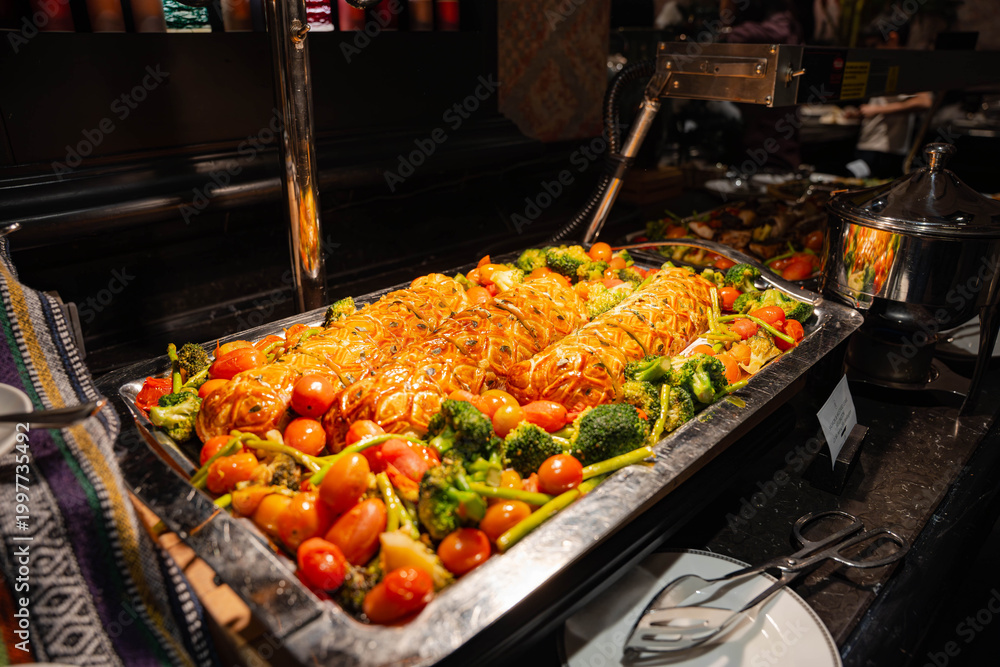 Obraz premium a large, golden-brown lattice-topped savory pastry roll displayed on a silver platter