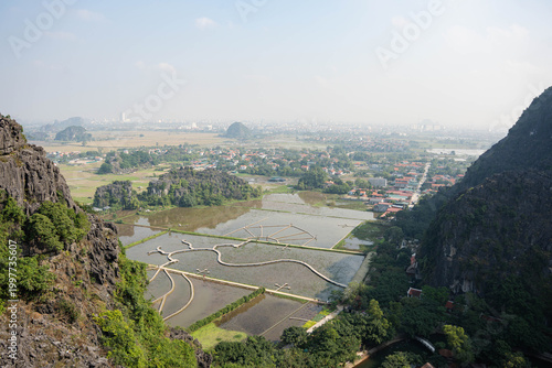  panoramic wide-angle shot overlooking a network of flooded rice fields and winding dirt paths in the Tam Coc region