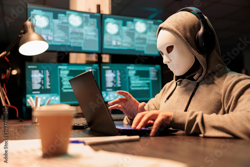 Foto Hacker with mask and hood breaking security server, installing virus to create computer malware and steal big online data