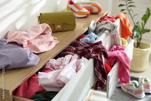 Cuadro en lienzo Chest of drawers with different messy clothes in room, closeup