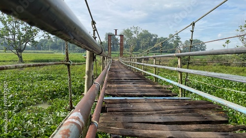 Rustic Suspension Bridge Over Water with Wooden Structure and Scenic Natural Landscape View