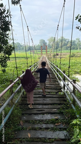 Children Walking on Suspension Bridge Outdoors in Lush Green Nature Landscape with Scenic View