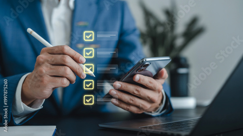A businessman holding a digital tablet and smartphone uses his finger to touch social network icons for smart mobile communication and online work