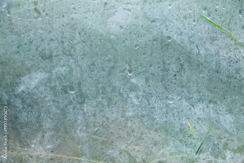 A captivating macro photograph featuring natural morning dew droplets and condensation collected on the surface of a sheet of clear plastic. The image captures the foggy effect created by countless sm
