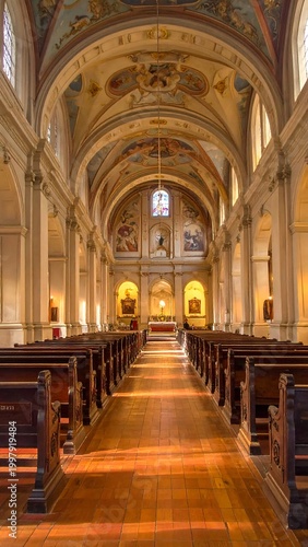 A long, ornate church aisle with pews and arched ceiling